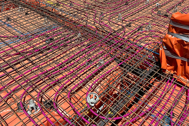Steel reinforcement mesh laid across large concrete slab during construction phase